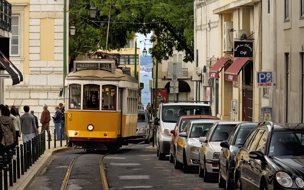 Elétrico amarelo subindo uma rua de Lisboa