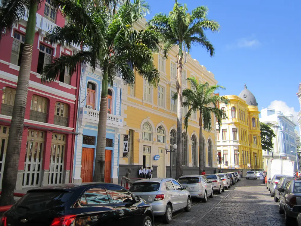 Rua de casarões coloridos e palmeiras no Recife Antigo