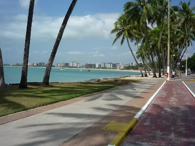 Orla de Maceió com coqueiros e mar verde